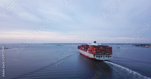 following a container ship moving trough the river exit in Charleston, South carolina, USA photo