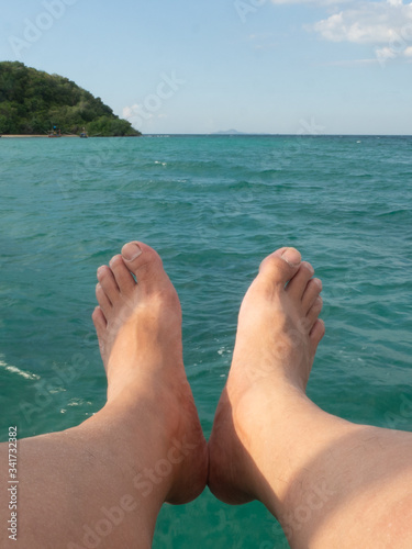 Legs of a man with a sea view.