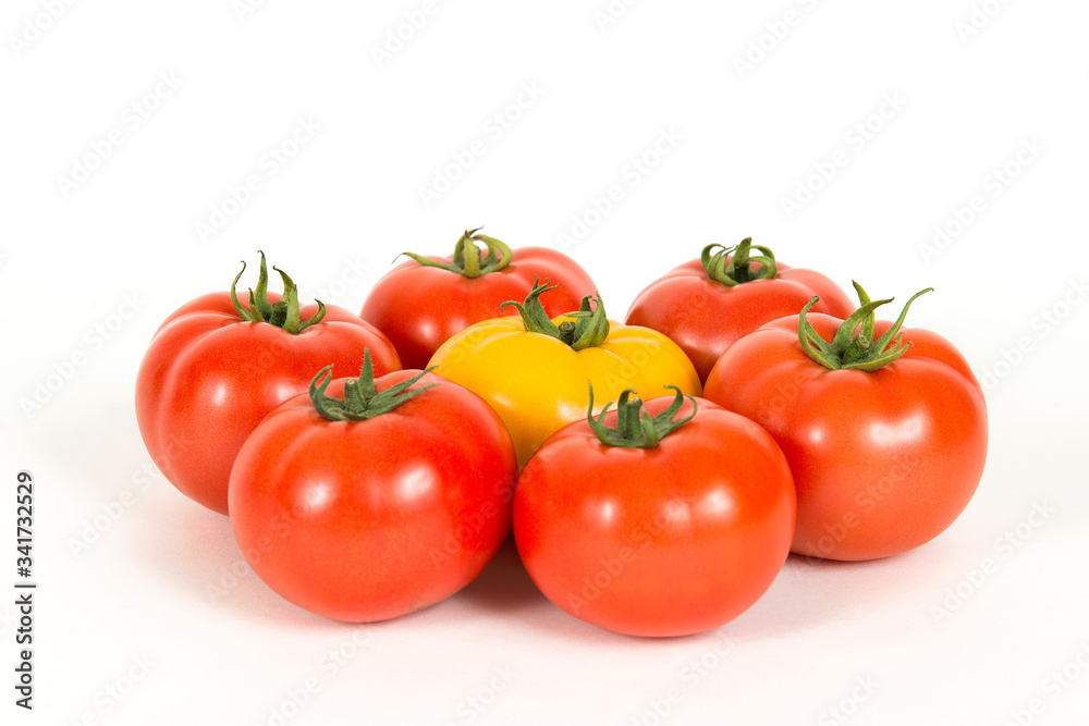 Group of red fresh tomatoes and one yellow tomate on a white background Group of red fresh tomatoes and one yellow tomate on a white background