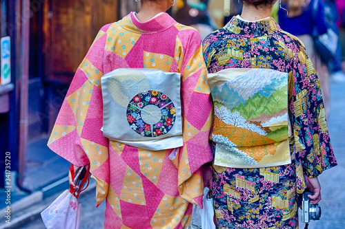 Two Geishas in Floral Japanese Silk Kimono on Streets of Kyoto City, Japan.