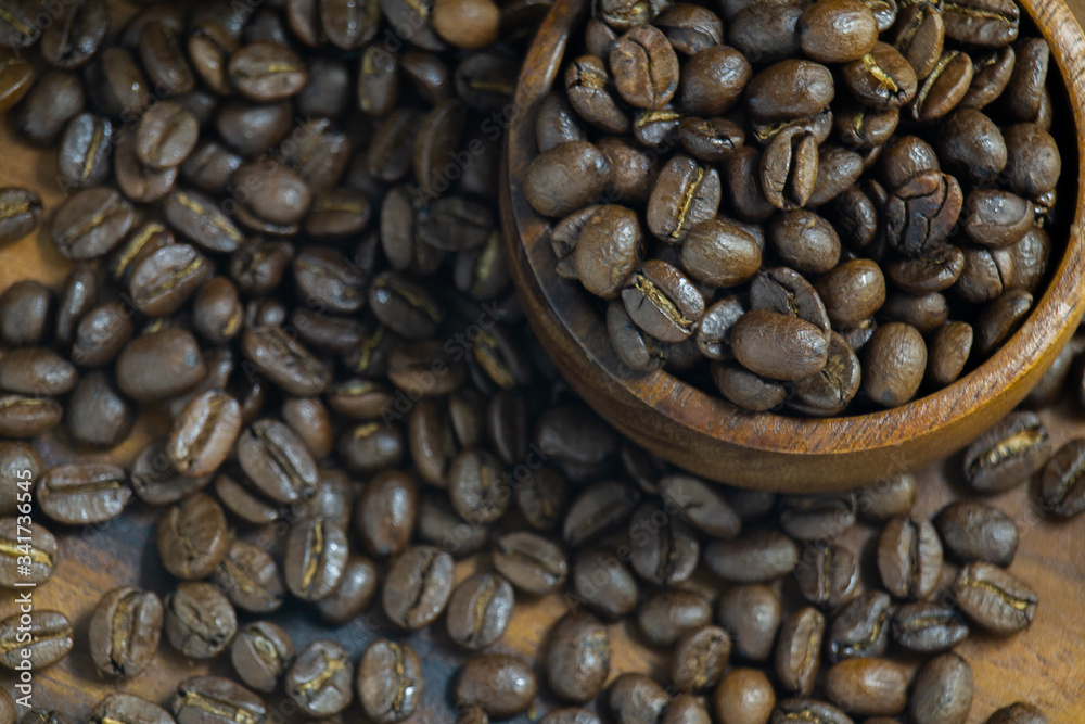 Fototapeta premium Roasted Coffee beans on grunge wooden can be used as a background