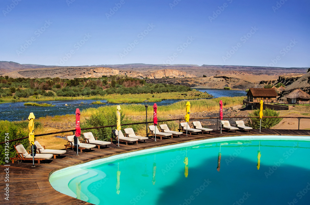 View at swimming pool in Felix Unite Camp and scenic landscape at the Orange river. in Noordewer Namibia.