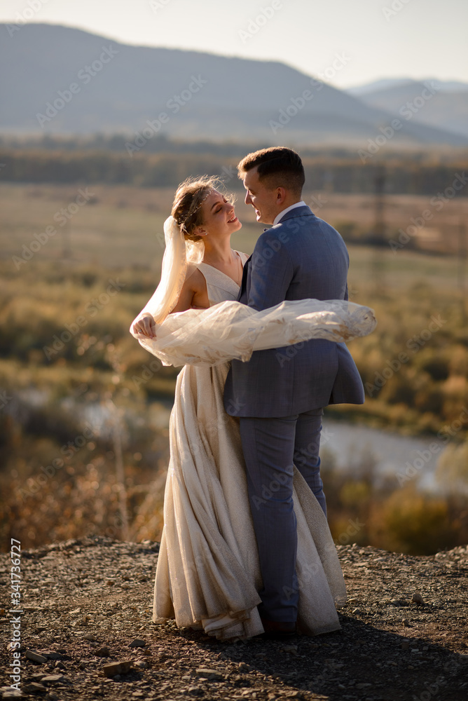 Wedding photo session of the bride and groom in the mountains. Photoshoot at sunset.