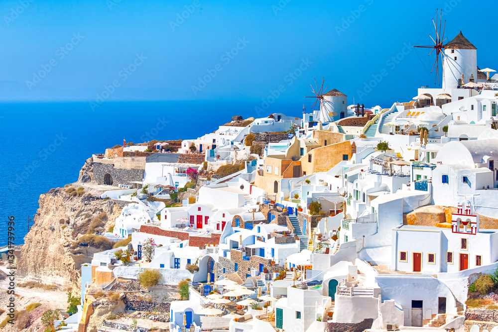 Greece Traveling. View of Greek Traditional Colorful Houses and Windmills of Oia or Ia at Santorini Island in Greece at Noon.