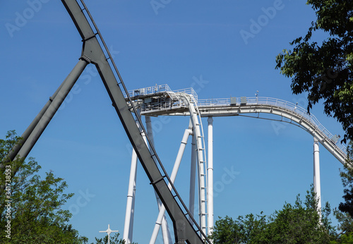 rollercoaster track curving down . Blue sky background
