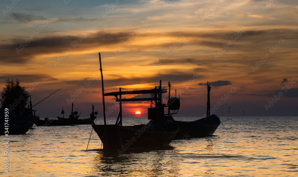 Silhouette of fishery wooden boat in sunset.