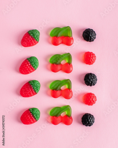 Colorful chewing sweets, sweets like berries on a pink background. Delicious marmalade, junkie food. Top view, copy space