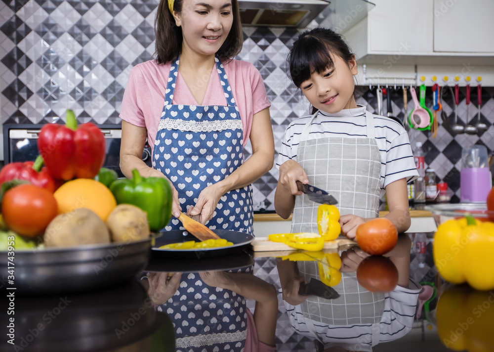 Asian families are cooking and parents are teaching their daughters to cook in the kitchen at home. .Family activities on holidays and Happy in recreation concept Asian families are cooking and parents are teaching their daughters to cook in the kitchen at home. .Family activities on holidays and Happy in recreation concept
