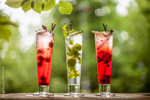 Cocktales lemonades on stone terrace on leaf background bokeh spring summer photo