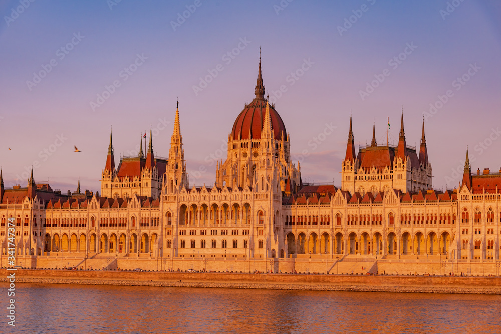 sunset over the river in the city of Budapest with the Parliament