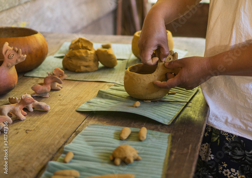 indigenous Lacandon Mayan woman forming clay figurines by hand
 photo