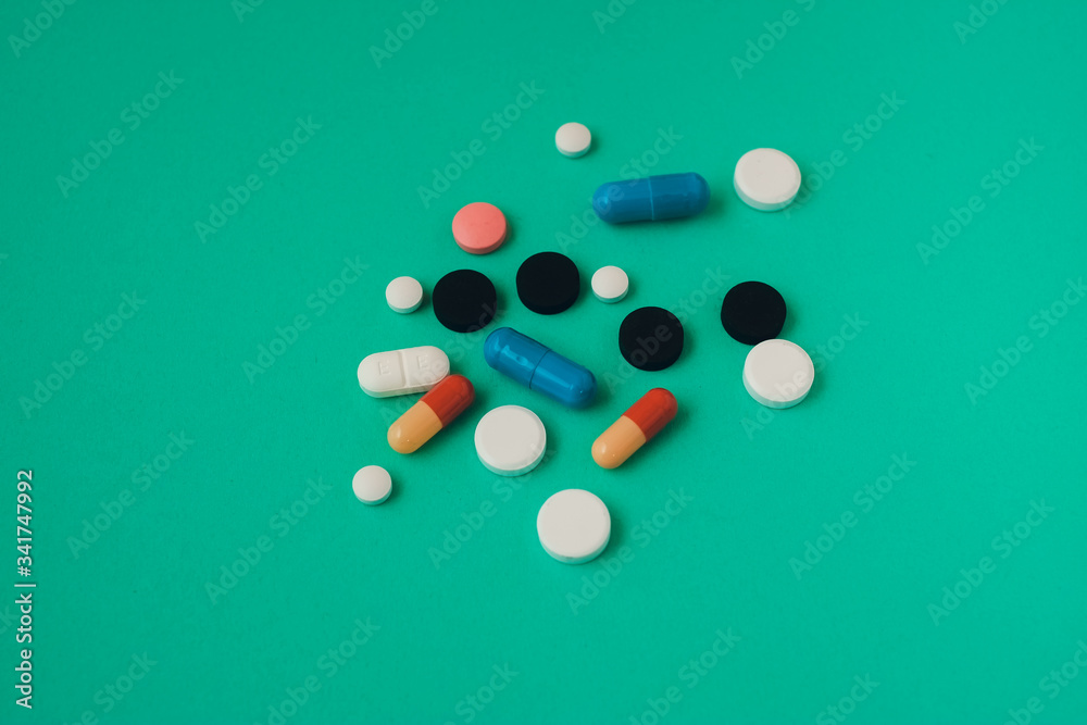 multi colored pills on green background