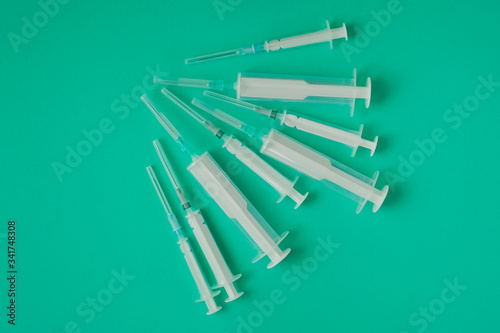 many syringes of different sizes on the green world