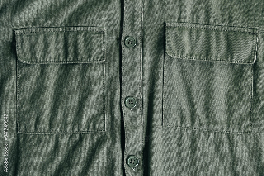 Two closed pockets and buttons on a winter green jacket. Top view. Copy, empty space for text