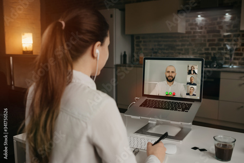 Rearview of businesswoman in a video conference with her boss and colleagues during an online meeting. Man in a video call with partners. Multiethnic business team having a discussion in a video call 