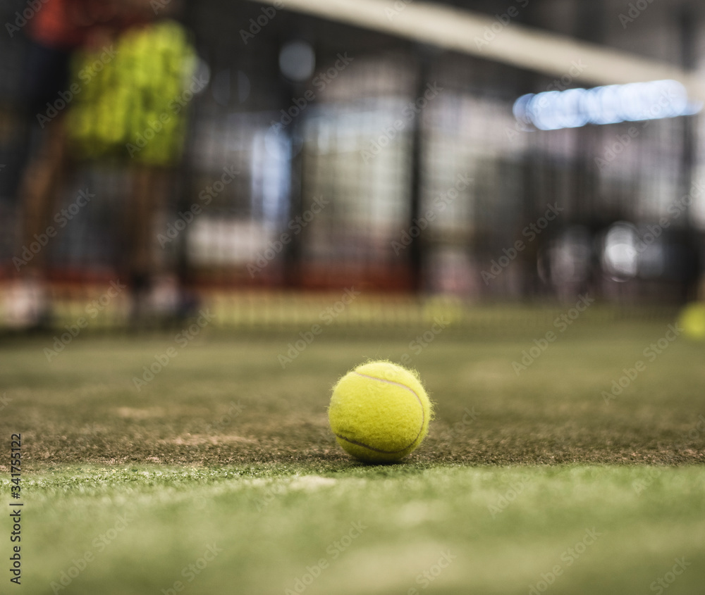 paddle tennis ball in court. Defocused man in background training