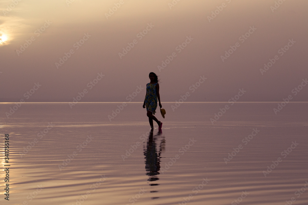 Woman walking at sea at sunset. Beach Summer Holiday Vacation Traveling Relaxation Concept 