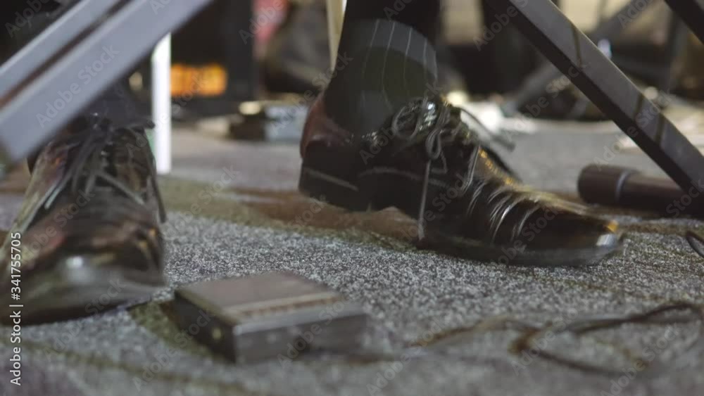 The foot of the musician stomps to the beat of the music. A man in shoes beats the beat to the music. Close-up. The foot of the musician stomps to the beat of the music. A man in shoes beats the beat to the music. Close-up.