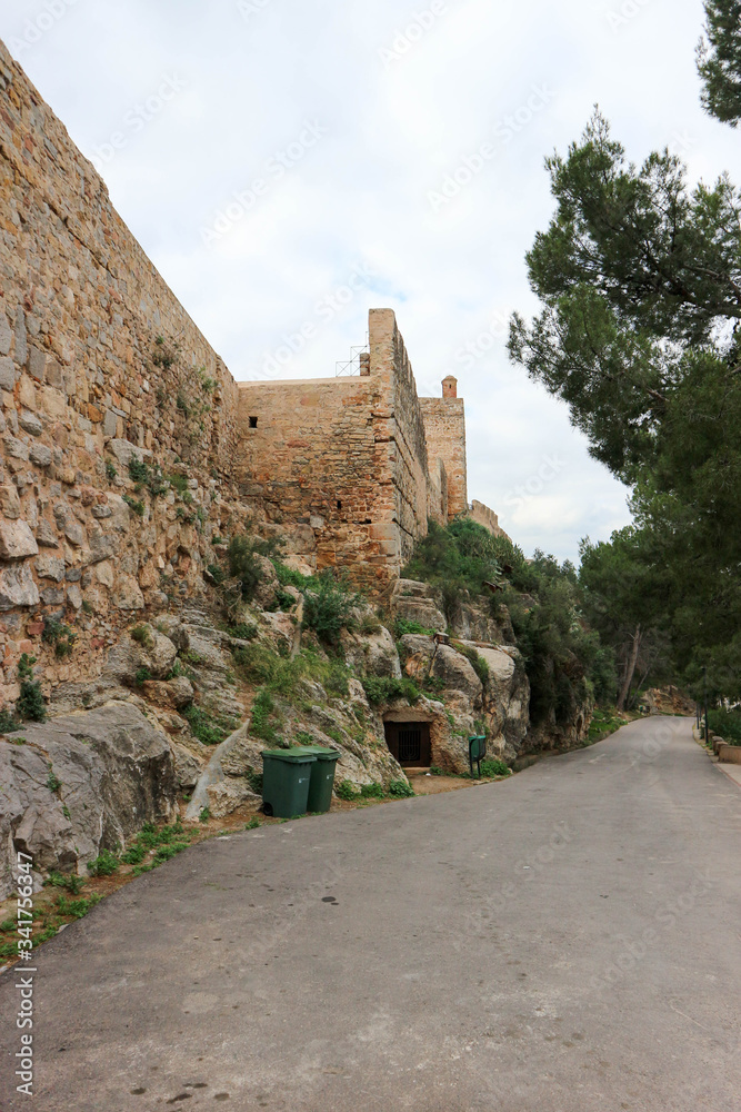 Road under the wall of old medieval Sagunto fortress, Valencia, Spain