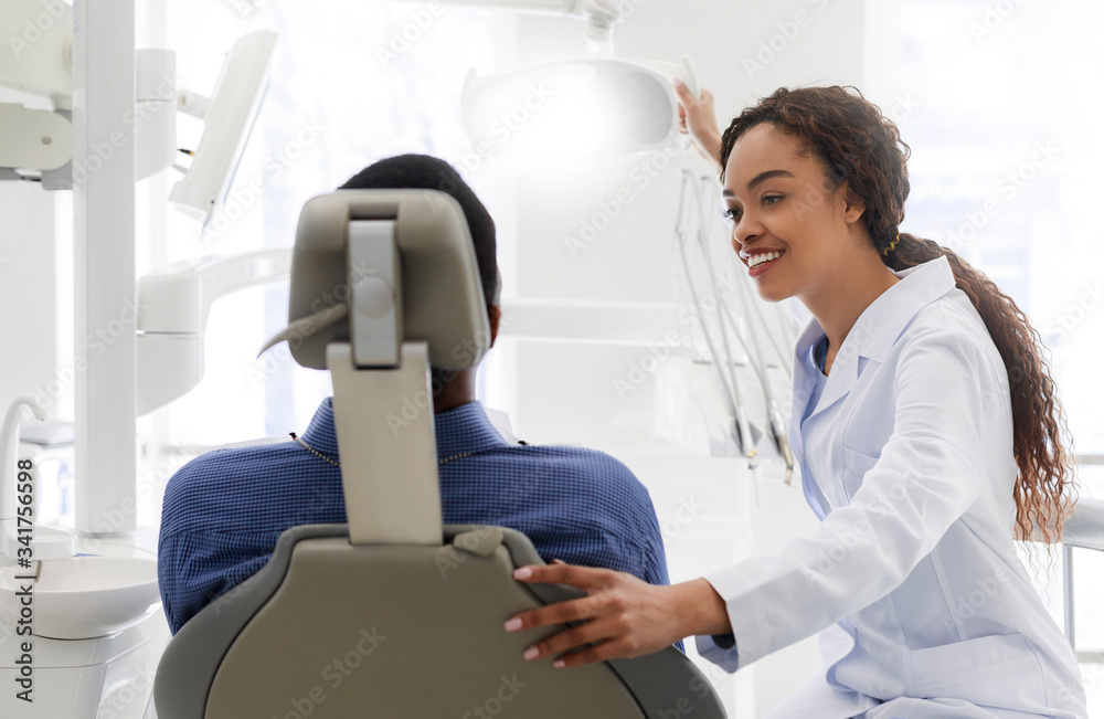 Friendly black female stomatologist greeting her patient Friendly black female stomatologist greeting her patient