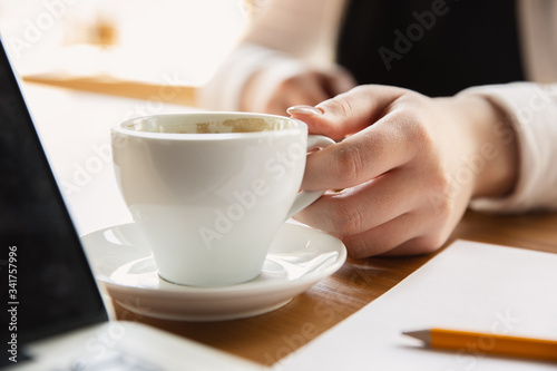Holding coffee cup. Close up of caucasian female hands, working in office. Concept of business, finance, job, online shopping or sales. Copyspace for advertising. Education, communication freelance.