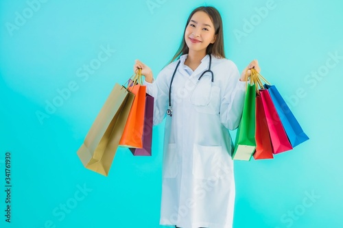 Portrait beautiful young asian doctor woman with colorful shopping bag