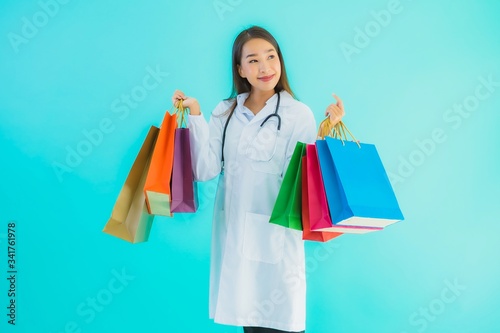 Portrait beautiful young asian doctor woman with colorful shopping bag