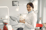 Woman in a uniform. Doctor working at the clinic. Dentist holds a skull in her hands