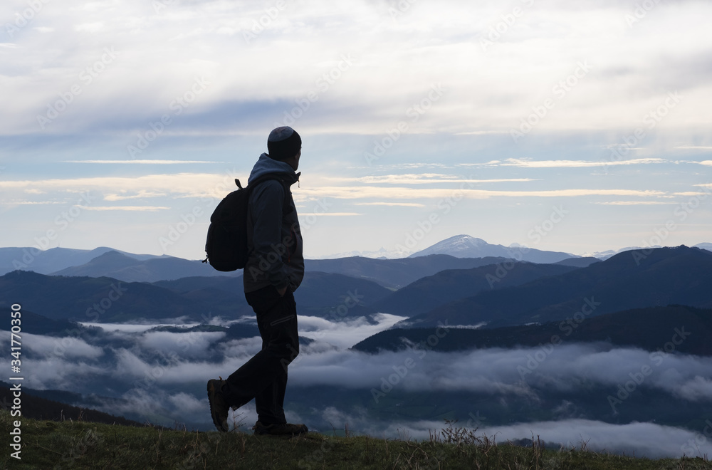 Hiker contemplating the mountains with sea of clouds from the natural park of Aiako Harriak, Euskadi