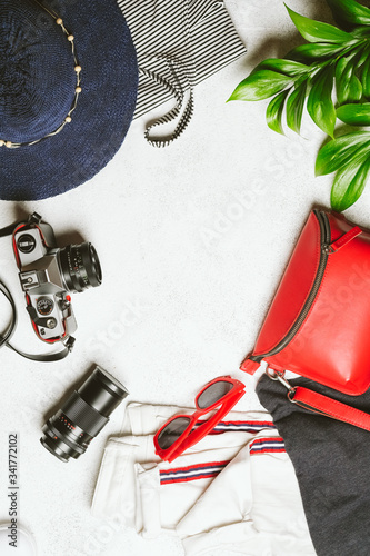 Set of women's clothing and accessories for summer holidays travel in red, blue and white colors. Travel vacation concept. Summer background. Top view copy space.