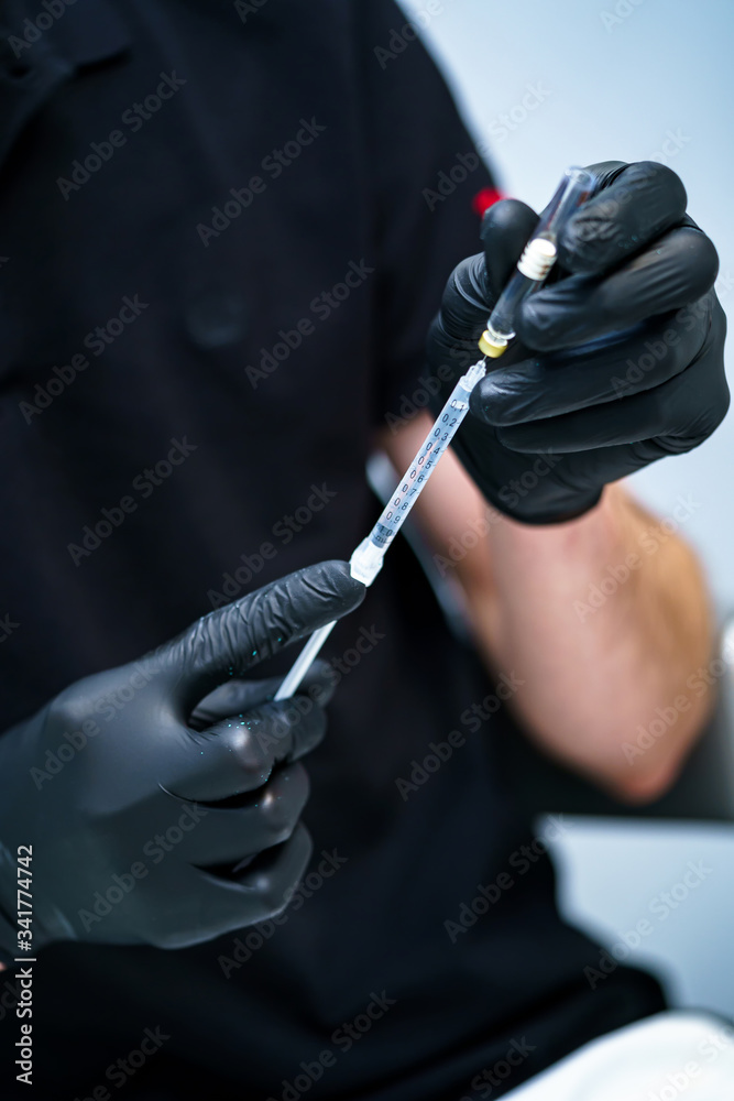Dental medical syringe with needle and carpula. Concept of anesthesia, injection in man`s hands.