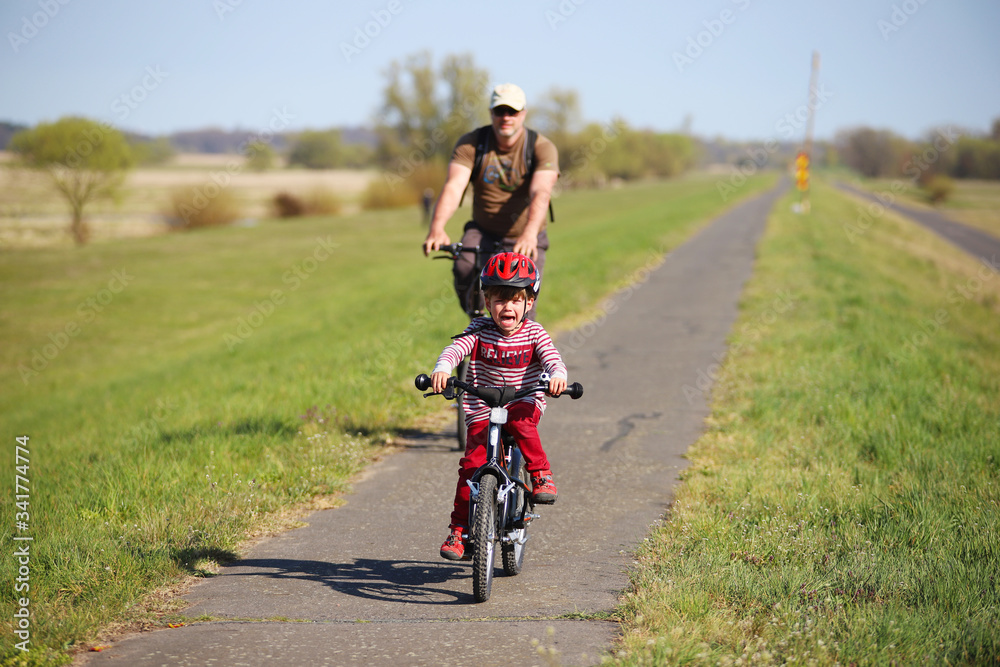 Ein Vater macht mit seinem Sohn eine Radtour auf dem Oderdamm während der Corona-Krise am 13.04.2020.