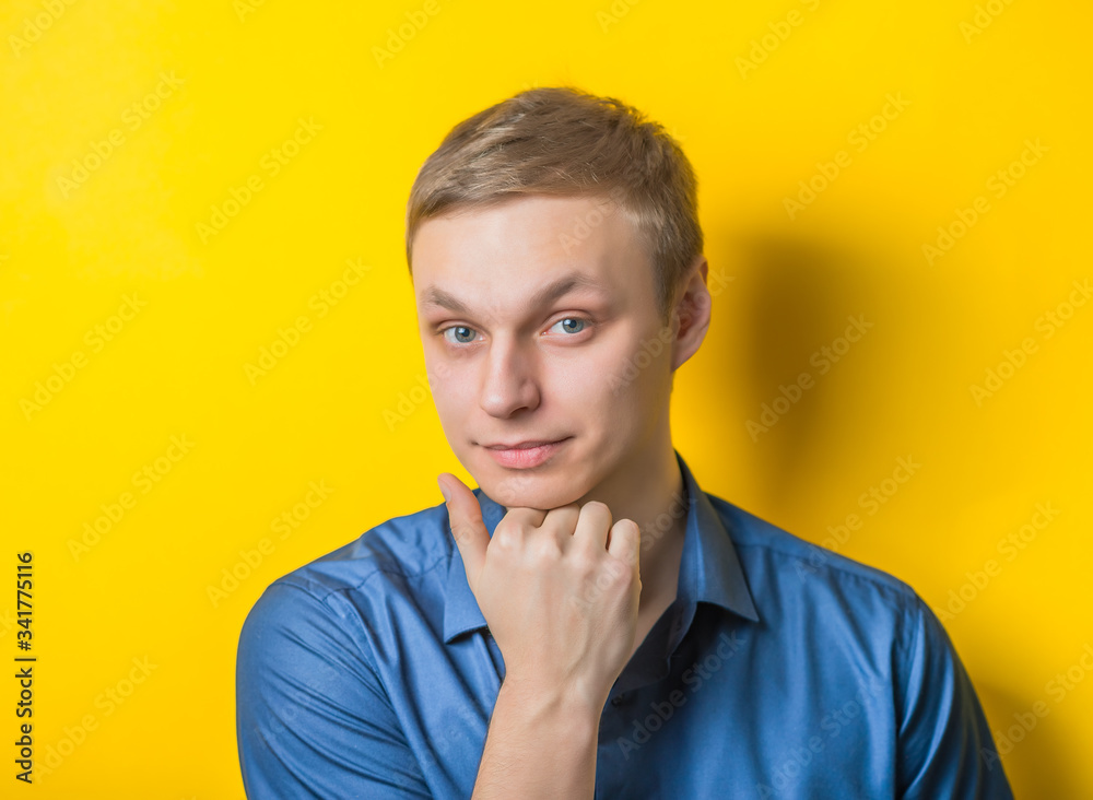 Handsome young man put his head in his hand. Close portrait. Supervisory gesture. Isolated yellow background. photo Handsome young man put his head in his hand. Close portrait. Supervisory gesture. Isolated yellow background. photo