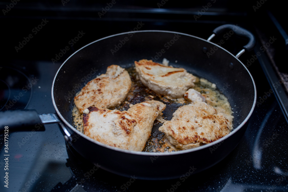 Frying or browning chicken breast stove top in butter and garlic Frying or browning chicken breast stove top in butter and garlic