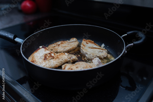 Frying or browning chicken breast stove top in butter and garlic © Tanya