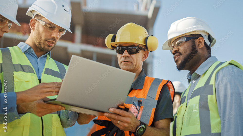 Diverse Team of Specialists Use Laptop Computer on Construction Site. Real Estate Building Project with Civil Engineer, Architectural Investor, Businesswoman and Worker Discussing Blueprint Plan Diverse Team of Specialists Use Laptop Computer on Construction Site. Real Estate Building Project with Civil Engineer, Architectural Investor, Businesswoman and Worker Discussing Blueprint Plan