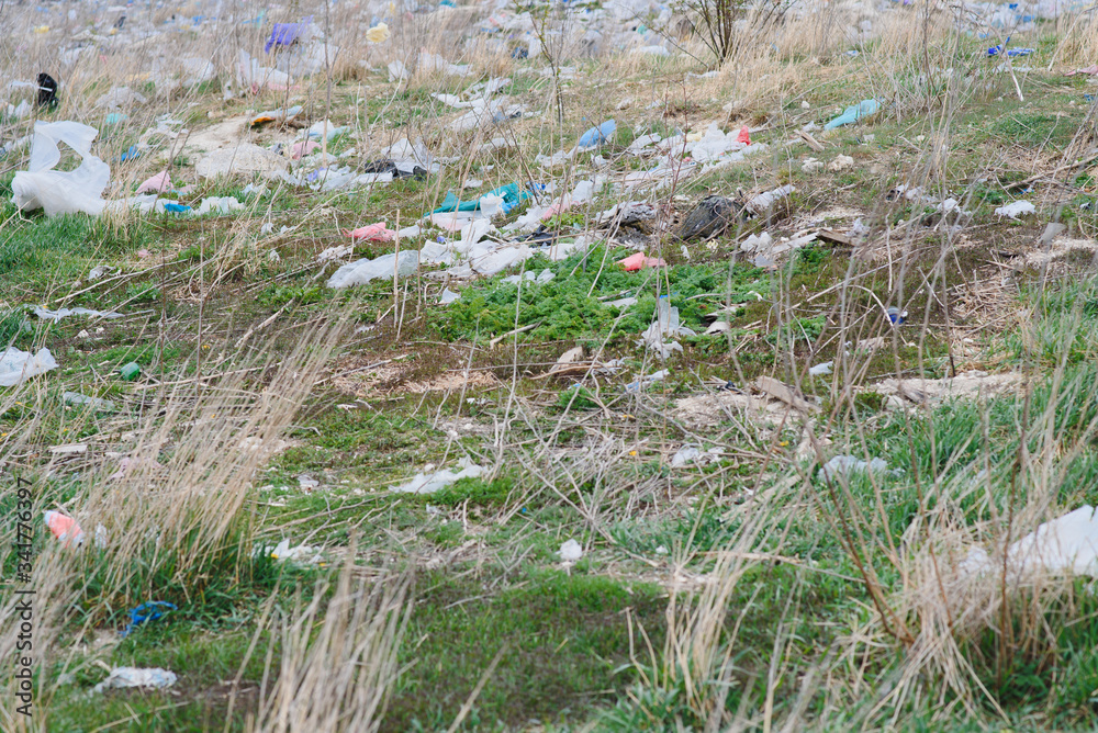 Fototapeta premium Ecological pollution of nature. Plastic bag tangled in plants against the backdrop of the mountains. Global environmental pollution. Recycling, clearing the land from plastic debris.