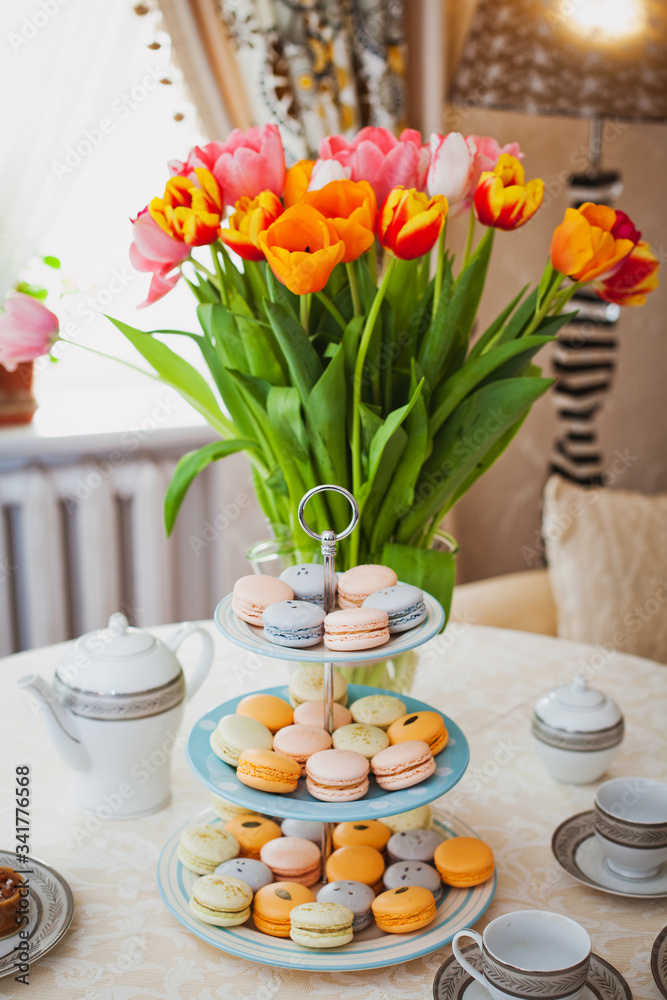 bouquet of tulips on a table with sweets and tea