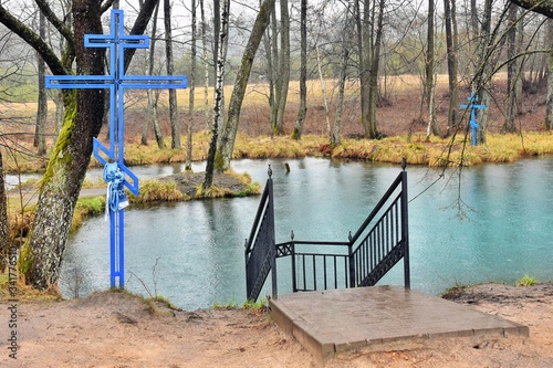 Blue Krinitsa. Sacred Spring with healing water and blue christian cross. Place of pilgrimage for Christians. Holy water. Landmark of Belarus. Amazing blue water in the holy lake.  photo