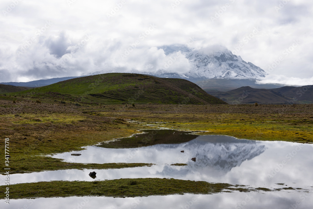 A view of cloud covered mountain peaks of the Andes mountain range with snow, high up in the Antisana Ecological Reserve high in Ecuador A view of cloud covered mountain peaks of the Andes mountain range with snow, high up in the Antisana Ecological Reserve high in Ecuador