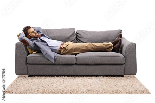Bearded man resting on a couch after work