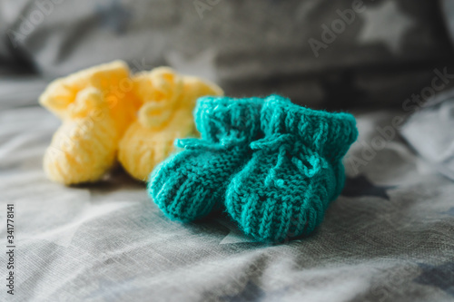 Fototapeta Naklejka Na Ścianę i Meble -  Mint and yellow knitted booties for a child.