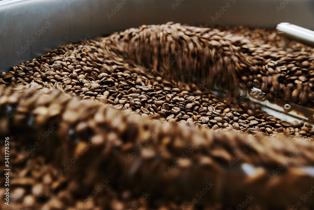 Obraz premium Coffee brown roasted beans. The roasting process in the roaster