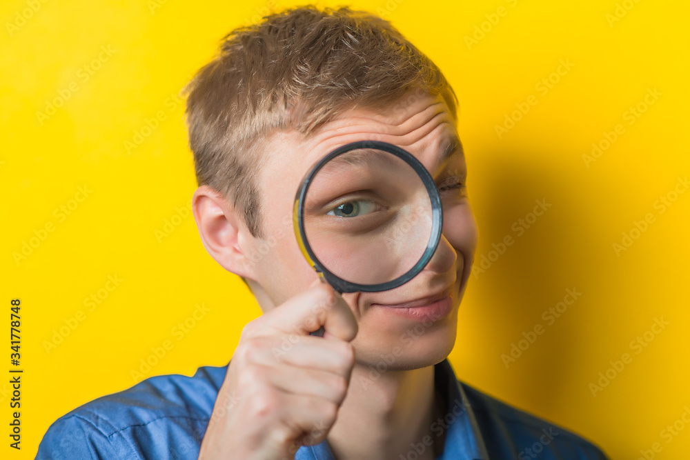 Man looking through a magnifying glass Man looking through a magnifying glass