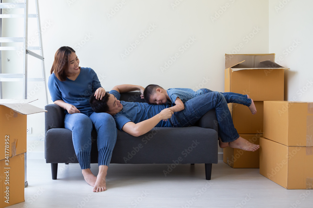 Happy Asian family having fun during moving day and relocating at new home. Moving house and new real estate concept Happy Asian family having fun during moving day and relocating at new home. Moving house and new real estate concept