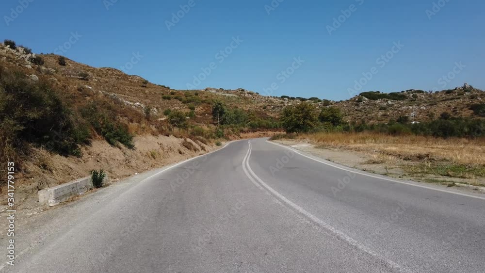 Cretan serpentine. Rear View Camera. Driving a car on a mountain road on a summer day. Crete island, Greece. Car rental and travel concept. Cretan serpentine. Rear View Camera. Driving a car on a mountain road on a summer day. Crete island, Greece. Car rental and travel concept.