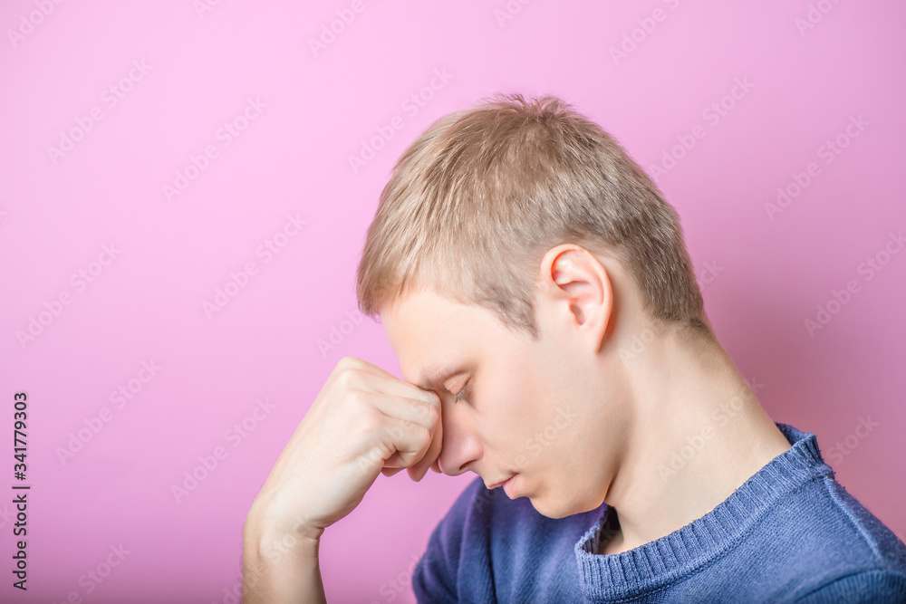 Young Man thinks. Put his head on his hand. Profile. Gesture. On a purple background. Young Man thinks. Put his head on his hand. Profile. Gesture. On a purple background.
