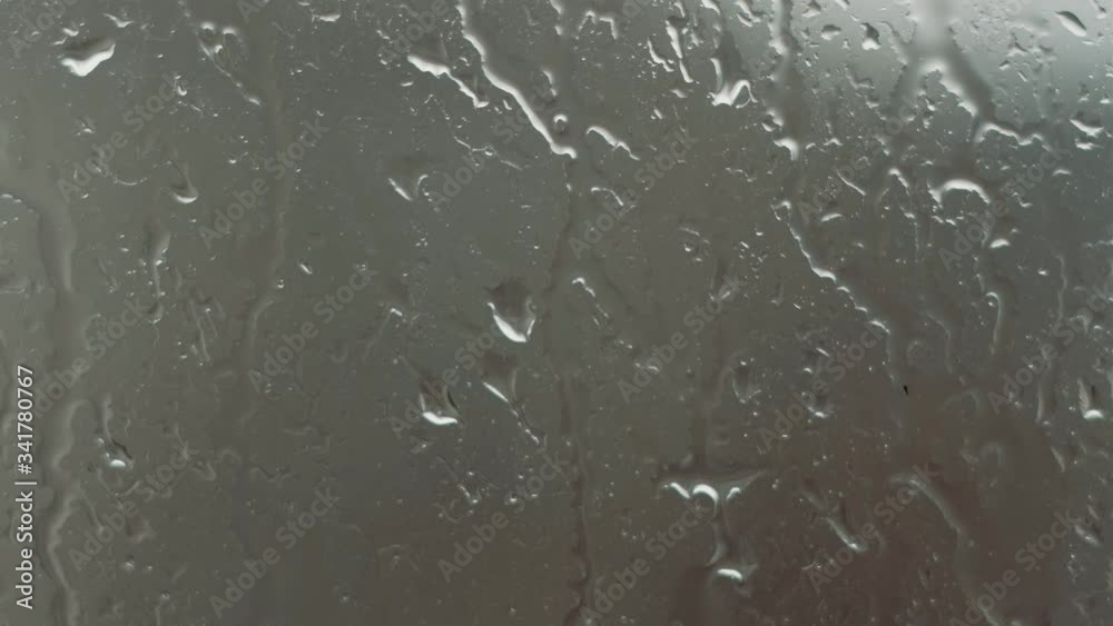 Close-up of water droplets on glass, Rain Rain, Go Away. Large rain drops strike a window pane during a summer shower. 4K. Close-up of water droplets on glass, Rain Rain, Go Away. Large rain drops strike a window pane during a summer shower. 4K.
