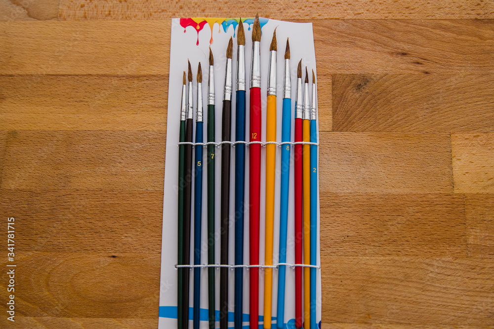 Obraz premium colored brushes on a wooden table