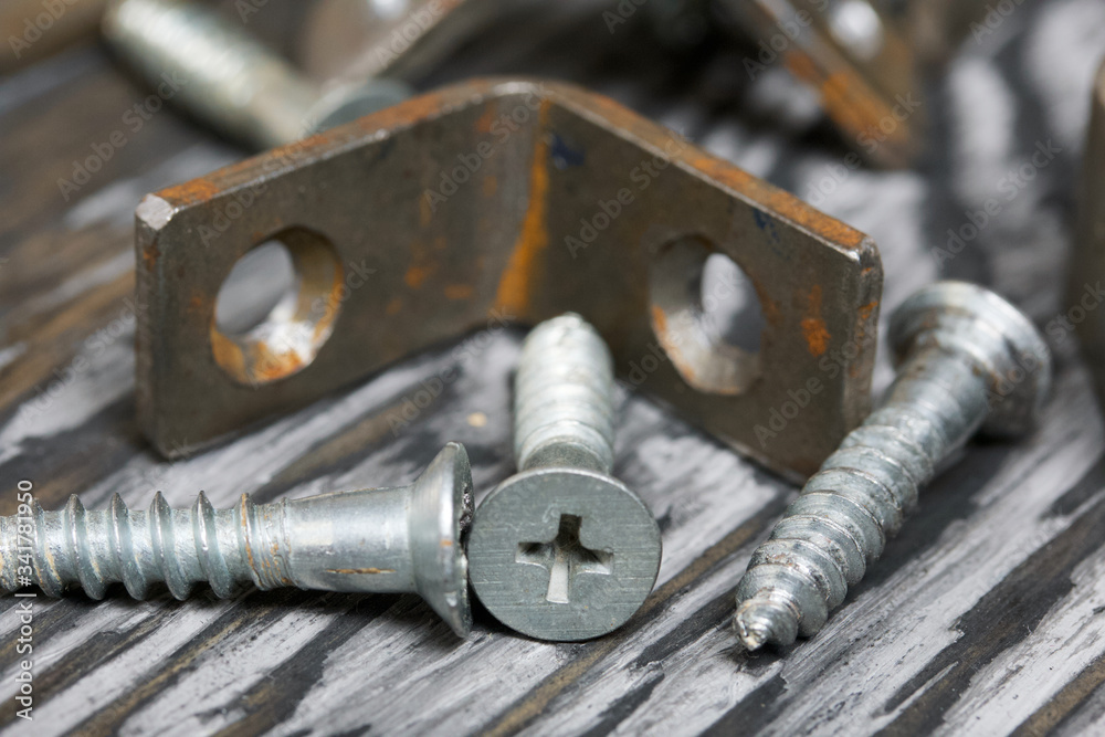 Metal corners with holes for screws. They lie on pine brushing boards painted black. World Labor Day. Metal corners with holes for screws. They lie on pine brushing boards painted black. World Labor Day.